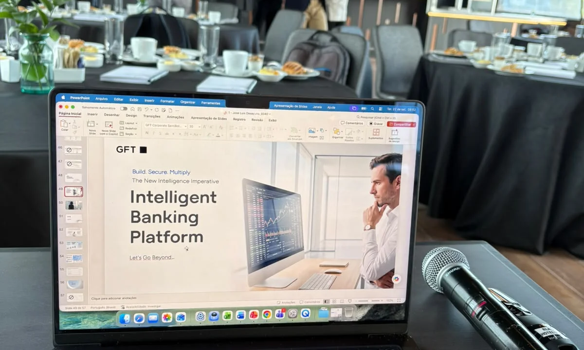Computador con una presentación de Intelligent Banking Platform de GFT y un micrófono durante el evento.