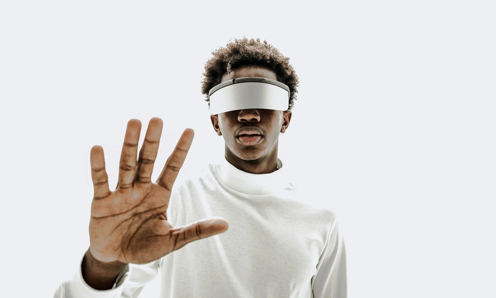 GFT Image - Mood - 19 Person wearing a virtual reality headset with a hand raised forward, symbolizing innovation and interaction in the digital world.