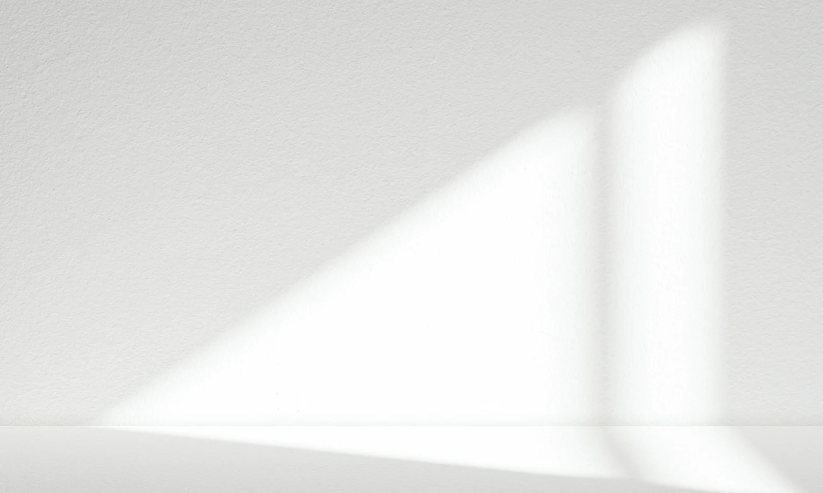 Abstract Minimalist Wall with Light and Shadow Soft white wall with geometric shadows cast by natural light, creating a minimalist and modern visual composition.