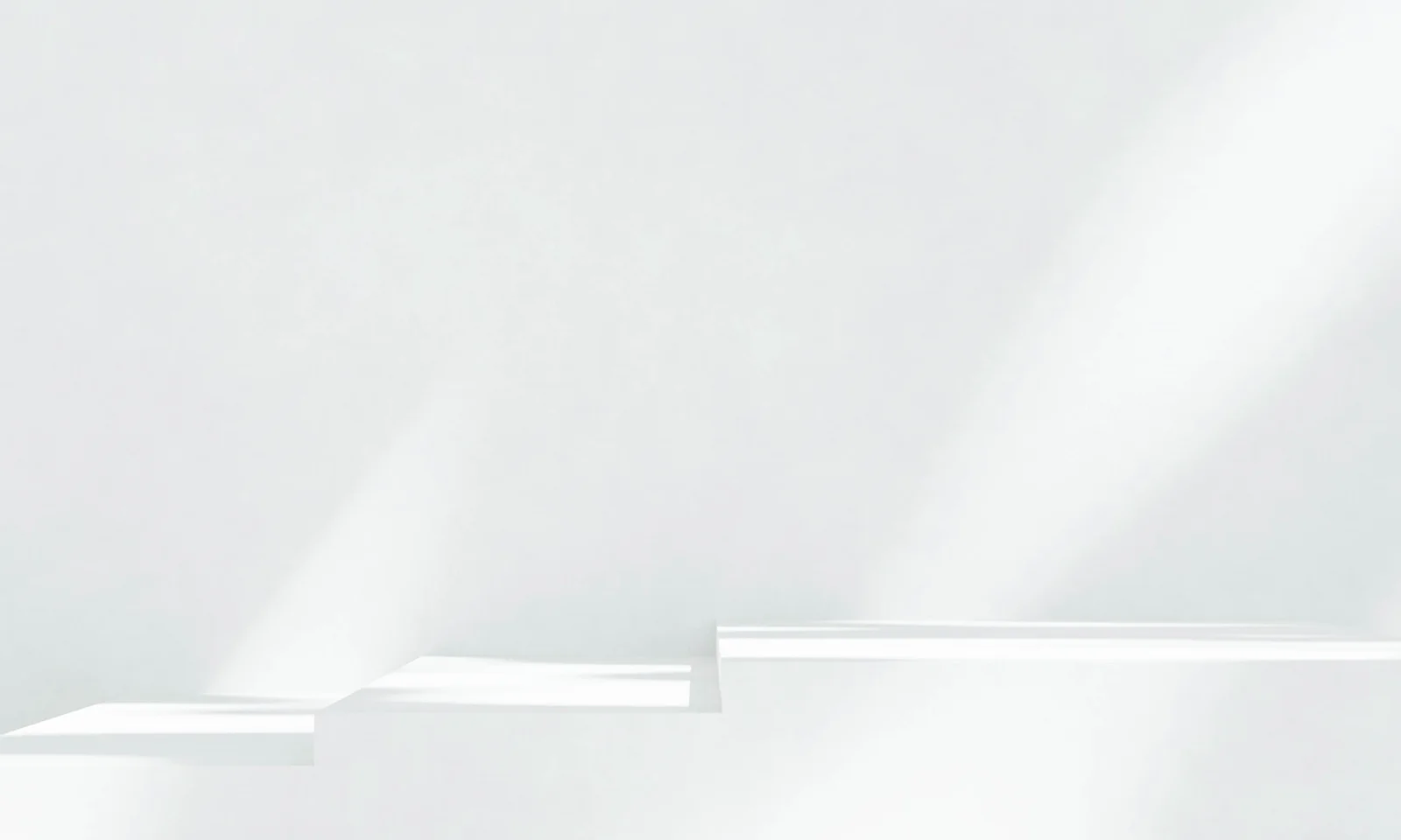 Clean white staircase illuminated by soft diffused light, creating subtle geometric shadows in a minimalist interior.