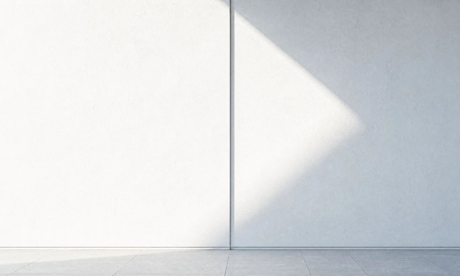 GFT Image: Digital Backoffice Strong diagonal beams of natural light casting bright and shadowed stripes across a textured white wall and smooth white surface.