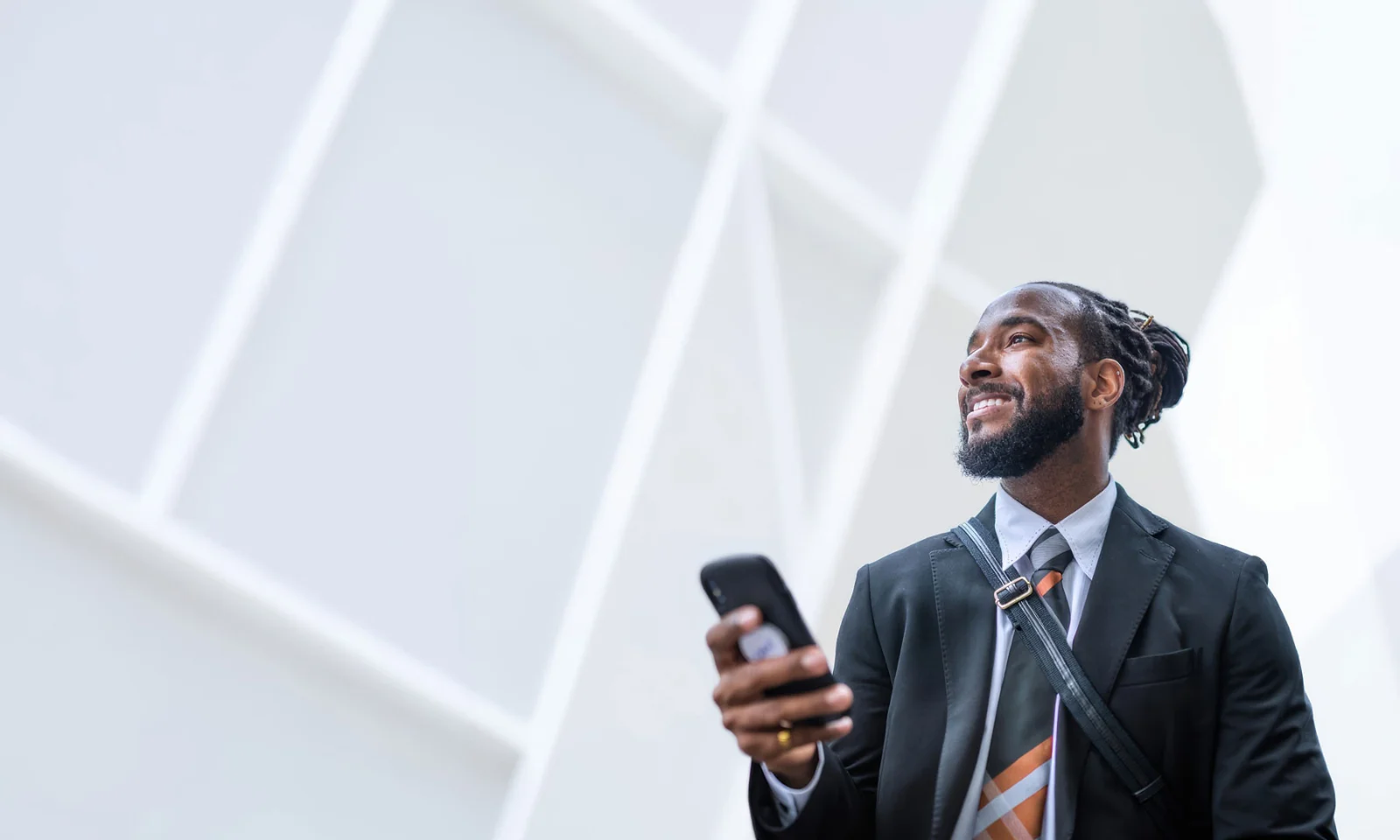 Profissional utilizando tecnologia móvel para negócios impulsionados por IA Um profissional de negócios utilizando tecnologia móvel em um ambiente corporativo moderno, ilustrando a transformação digital impulsionada por IA e as experiências de negócios conectadas. A imagem representa como as organizações aproveitam a tecnologia inteligente, os dados e a engenharia de software para melhorar a produtividade, a tomada de decisões e o engajamento do cliente.