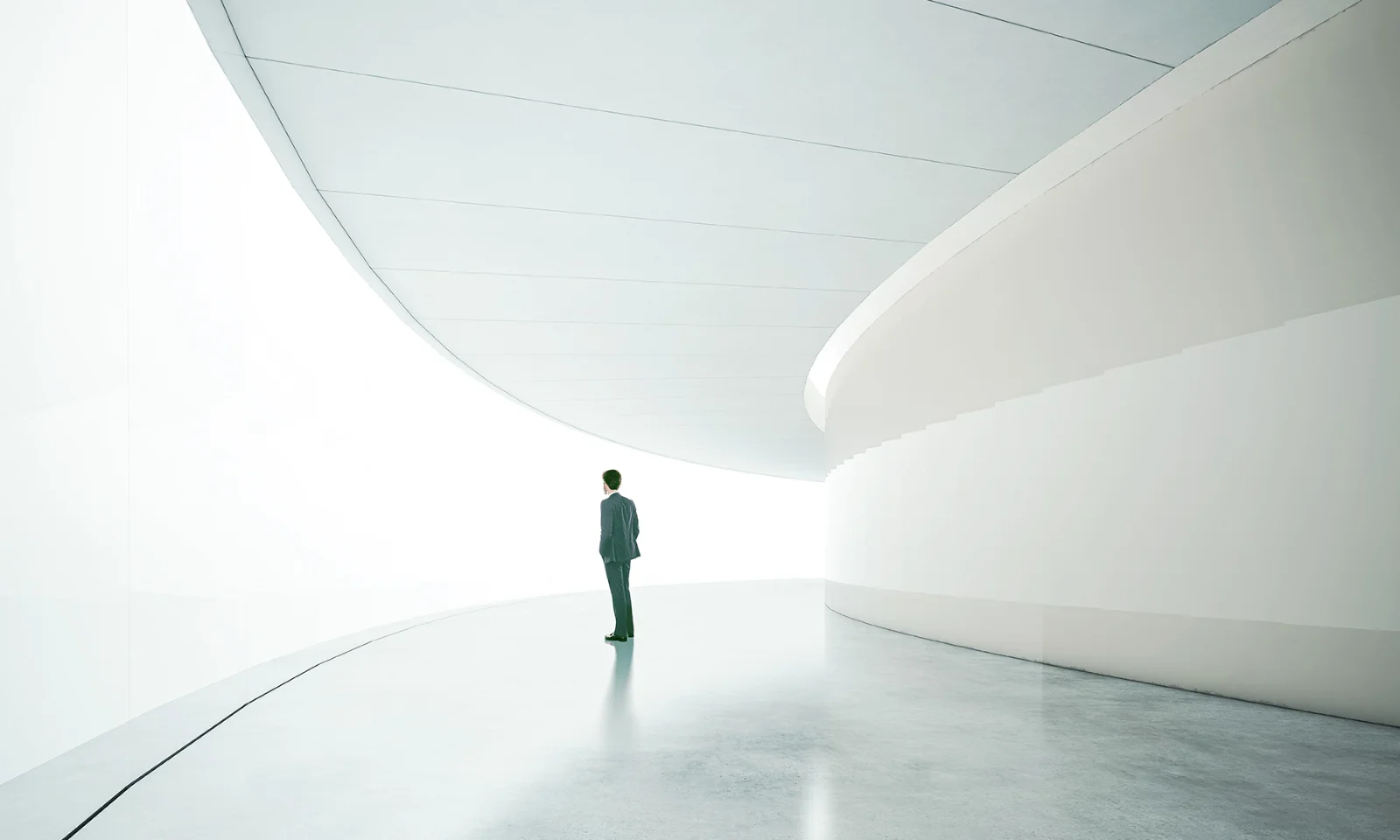 GFT Blog - IA o samba da inovacao e da responsabilidade Person standing in a futuristic, minimalist corridor filled with light, symbolizing exploration, vision, and technological progress.