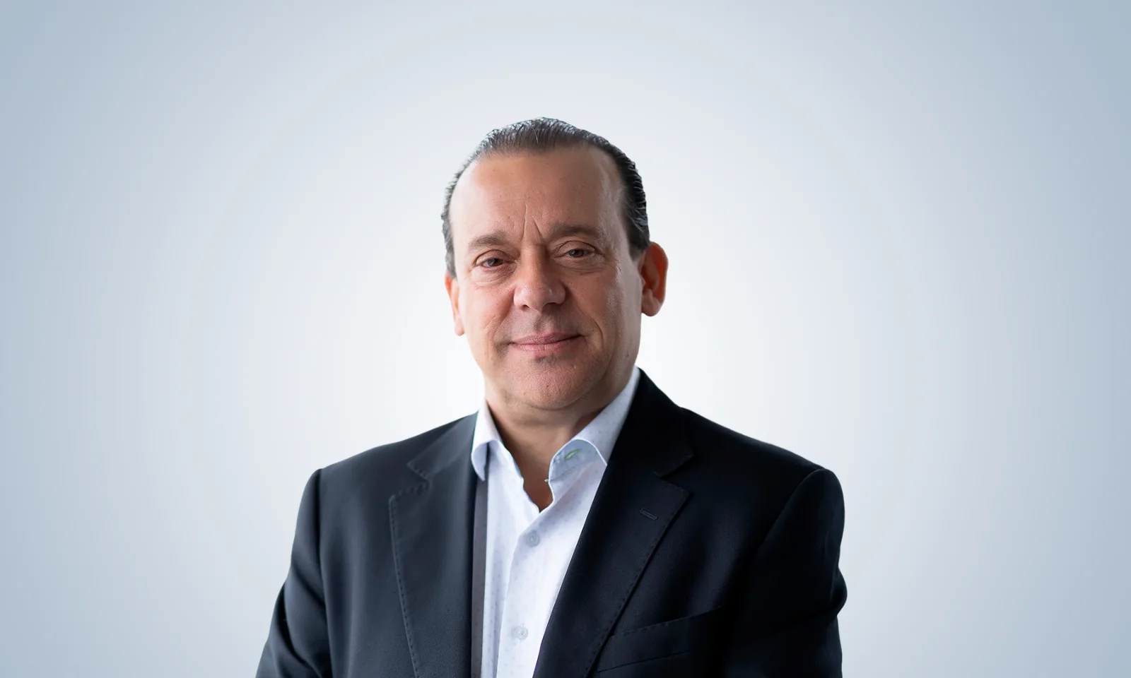 Retrato de cuerpo entero de Alberto Rosati, vistiendo un traje azul y de pie con confianza.