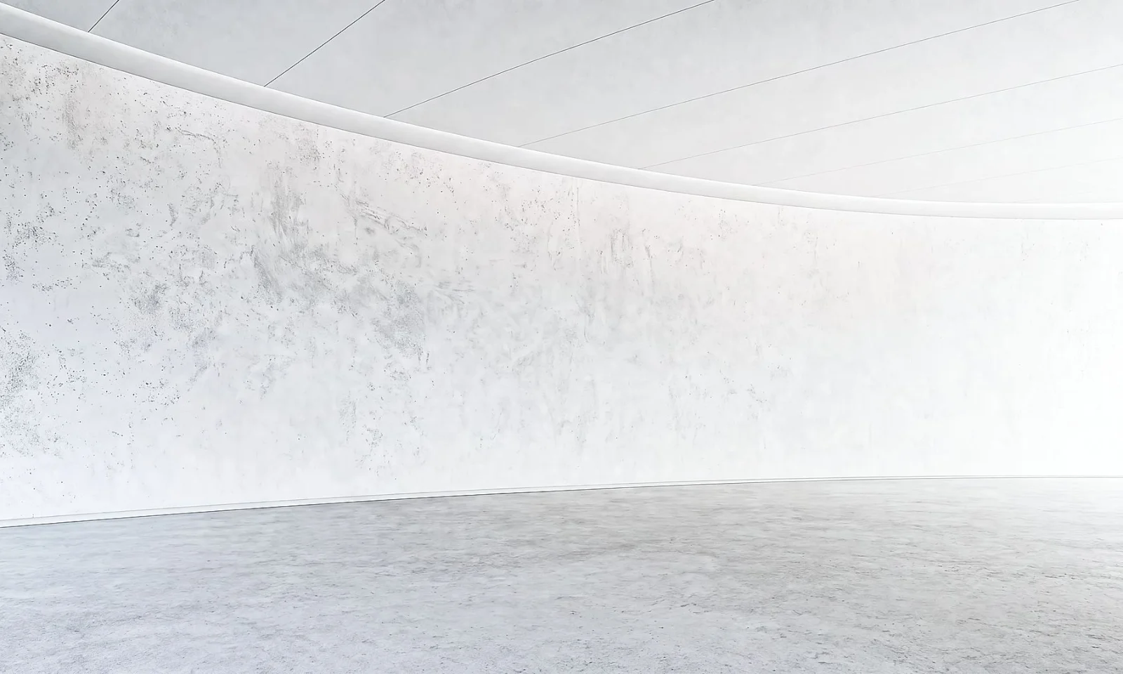 Intérieur minimaliste en béton blanc, avec des murs courbes, des lignes épurées et un espace ouvert.