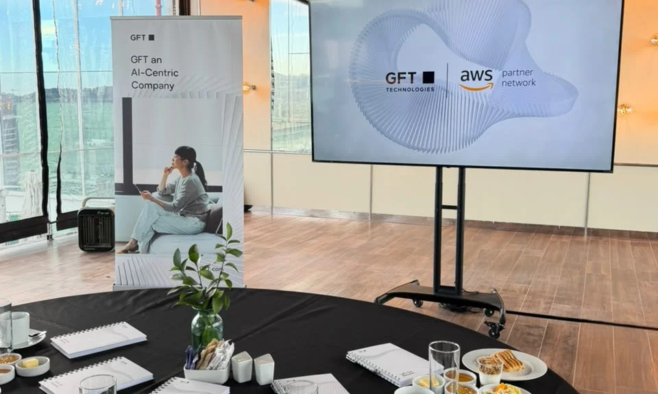 Espacio del evento AI-Powered Legacy Modernization con branding de GFT y AWS.