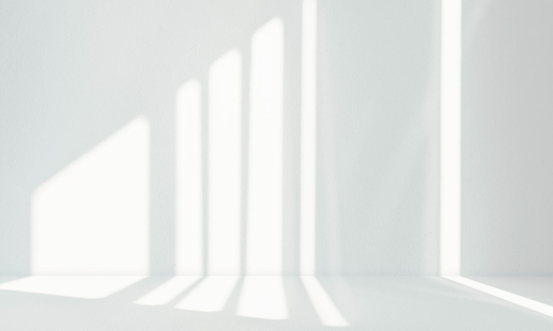 GFT Solution: Google Cloud Data Management Soft vertical beams of natural light cast across a smooth white wall and floor, creating a clean and minimalist geometric pattern.