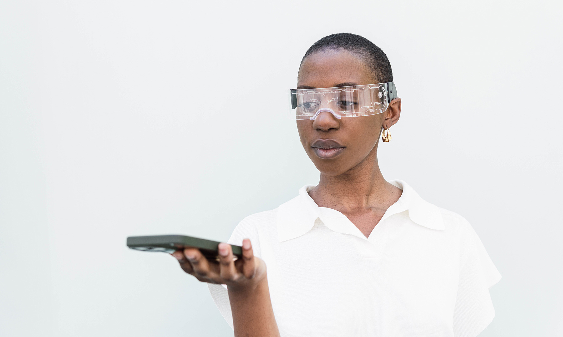 Person wearing a white shirt holding a smartphone in one hand against a plain white background.