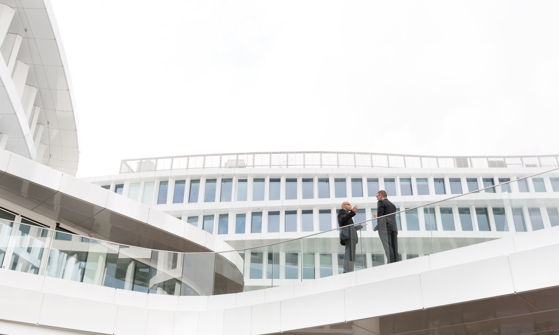 Minimalist abstract composition featuring overlapping white geometric panels arranged in a curved, layered pattern on a clean light background.