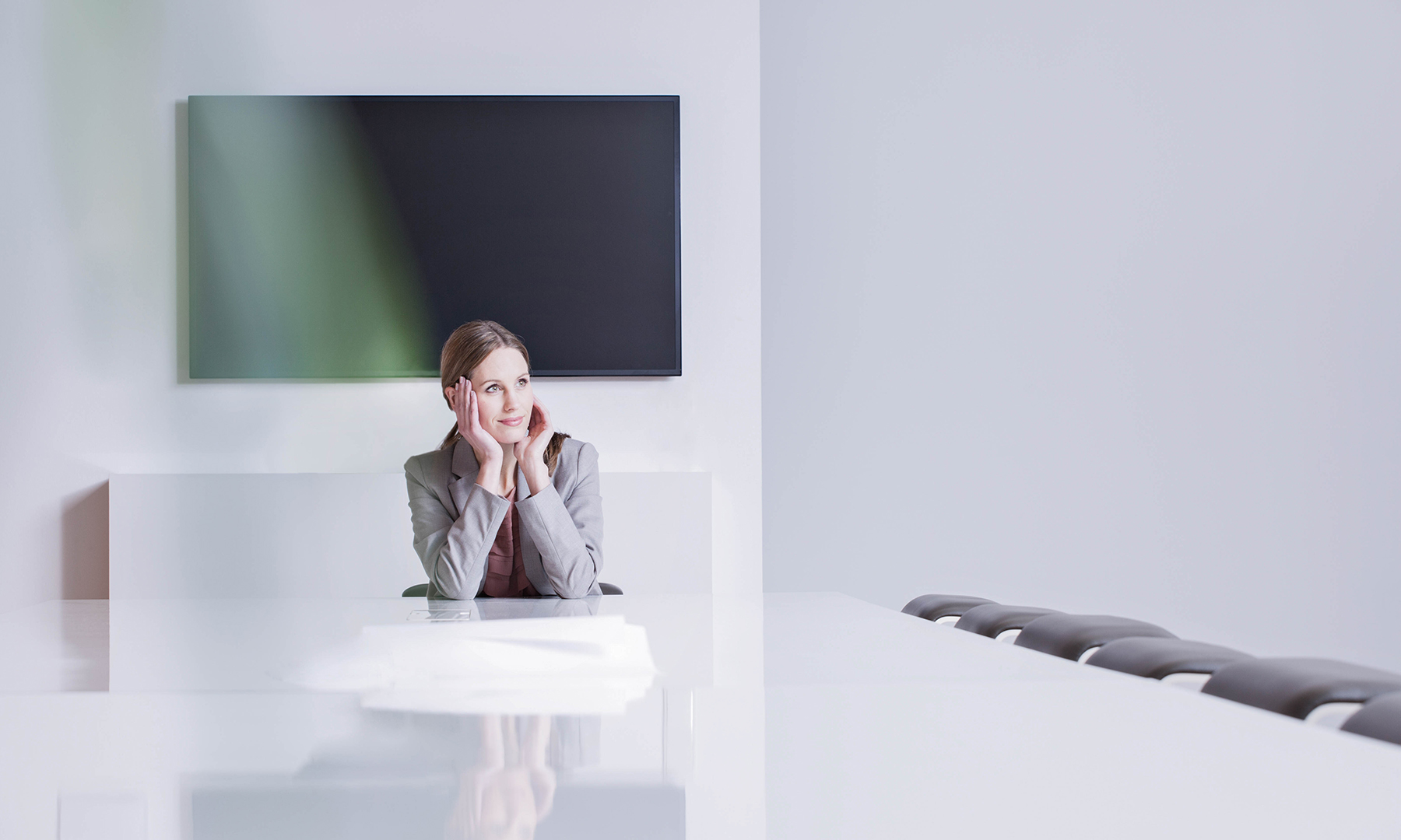 Business professional sitting in a modern conference room, reflecting on ideas and strategies for innovation and growth.
