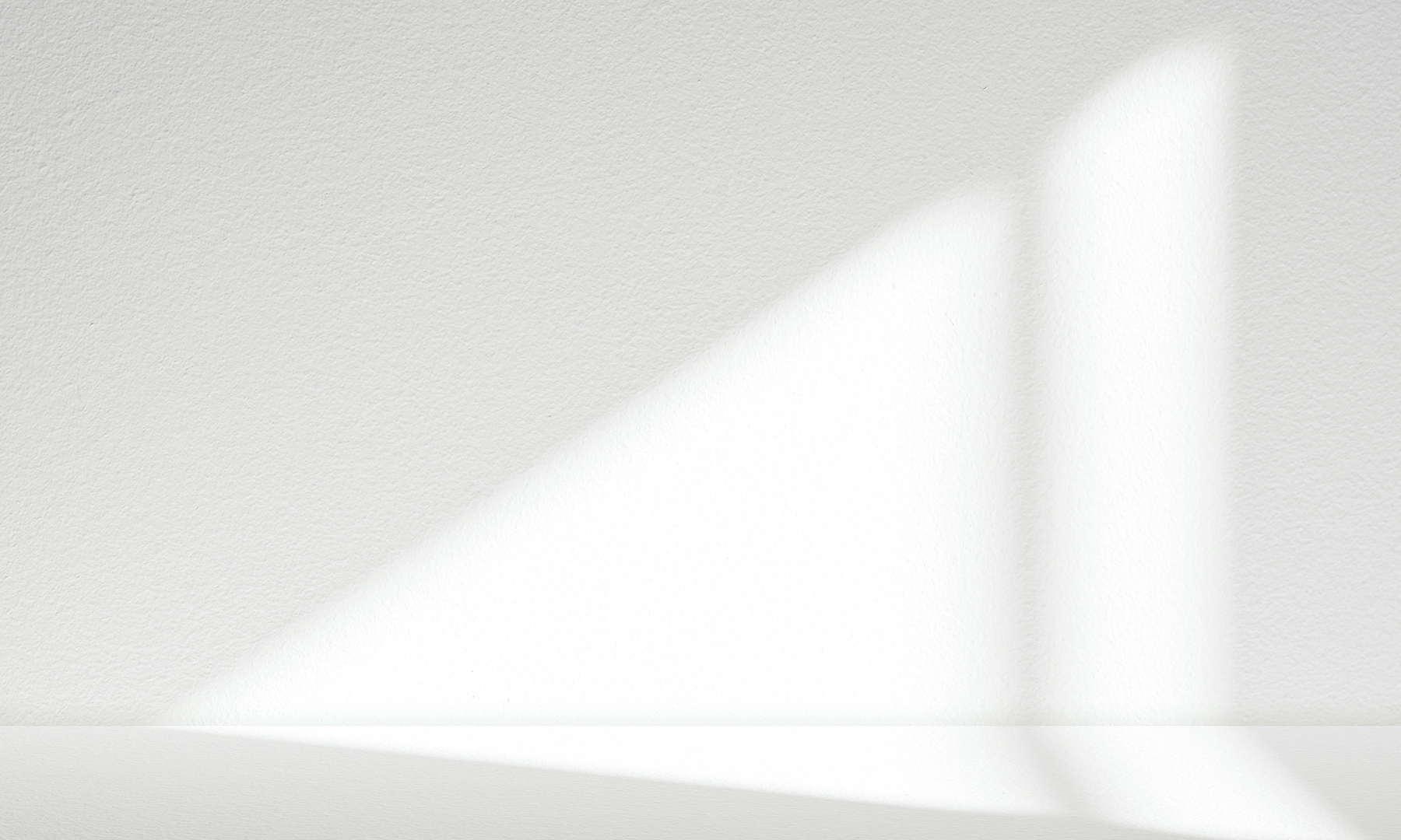 GFT Solution: Cloud Security Hardening Bright triangular sunlight and vertical light bands projected onto a smooth white wall and surface, creating soft geometric shadow patterns
