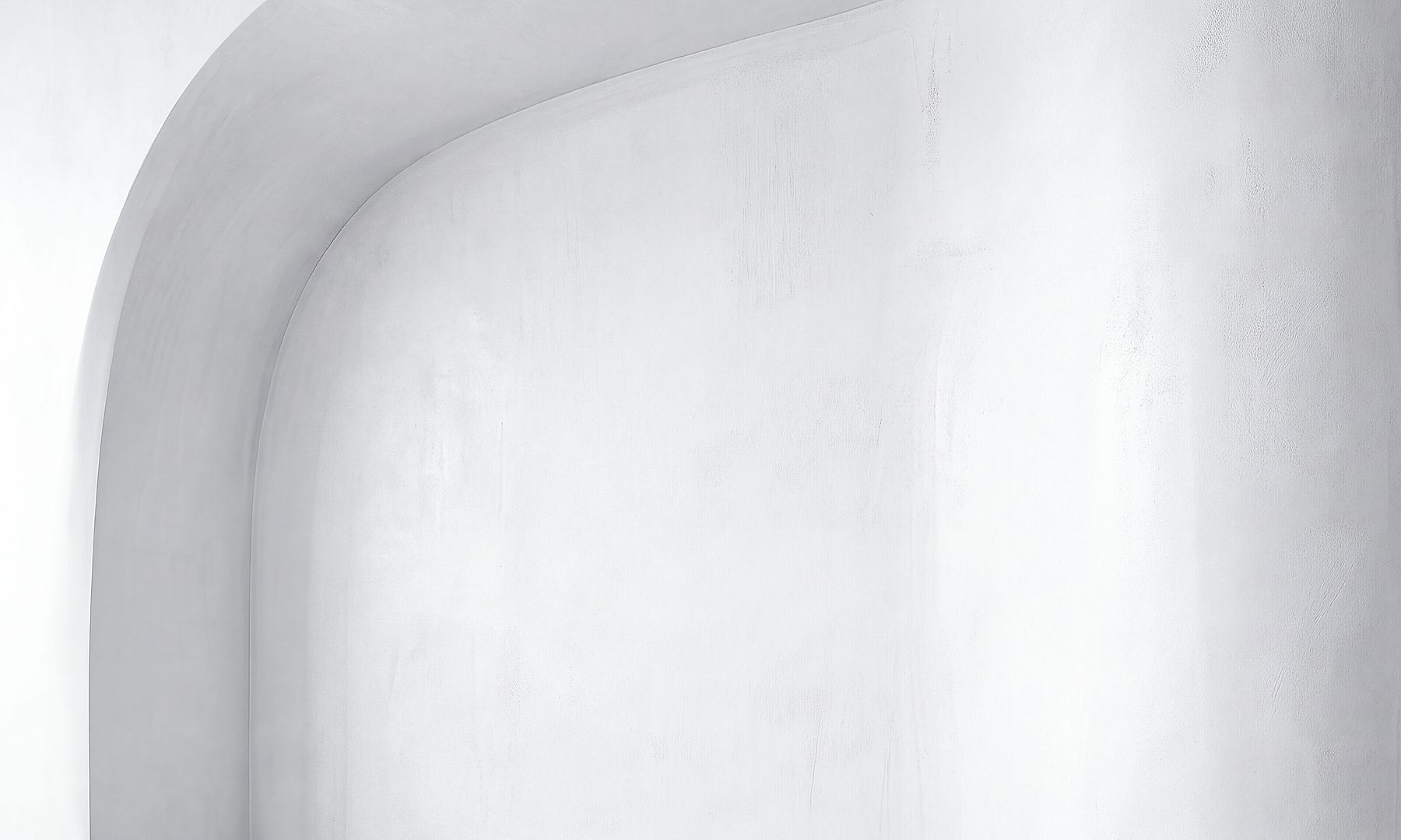 GFT Solution: Advisory and Change Management Smooth white concrete archway with a curved architectural form illuminated by soft natural light.