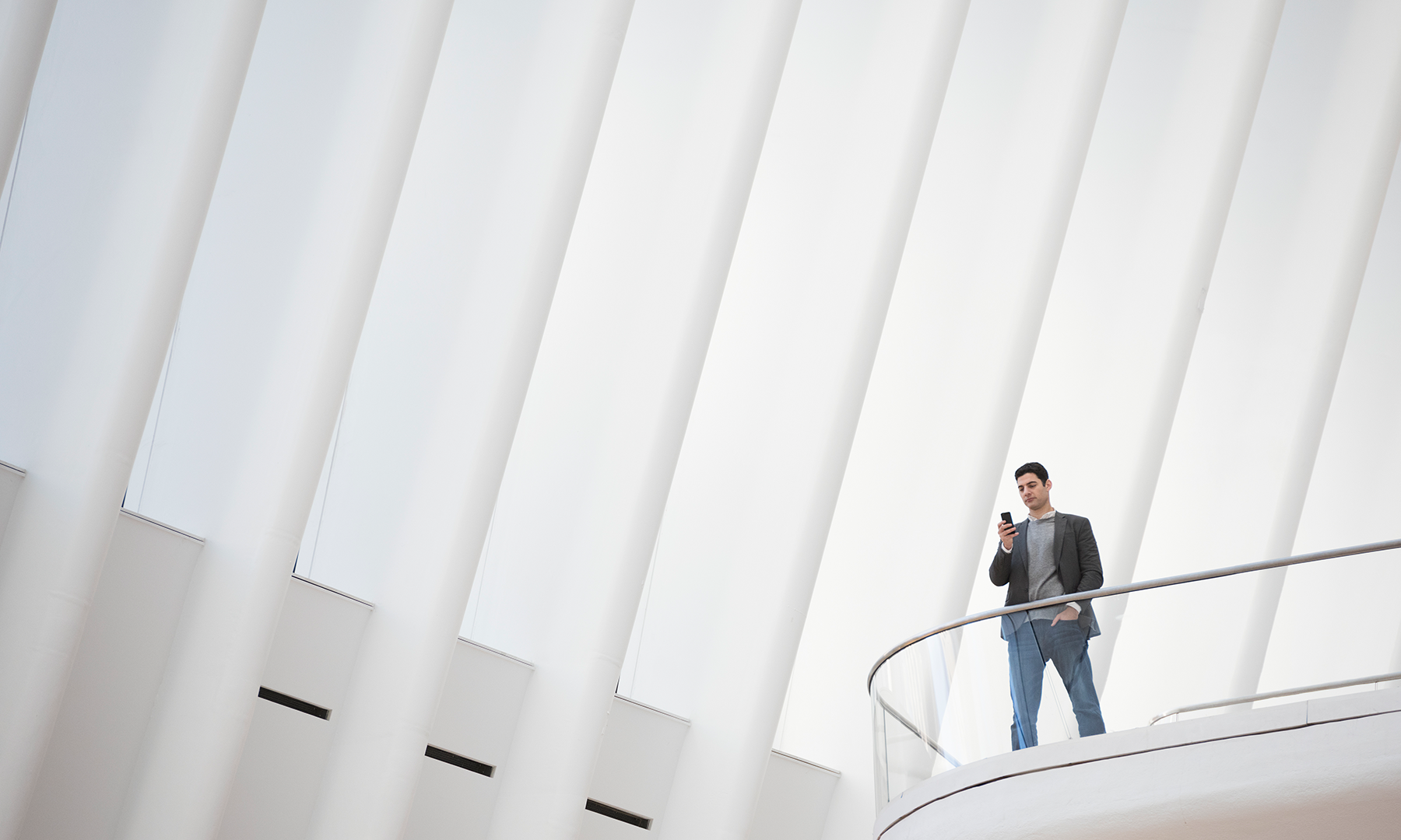 Curved arrangement of layered white geometric panels forming a flowing, wave-like architectural pattern on a light background.