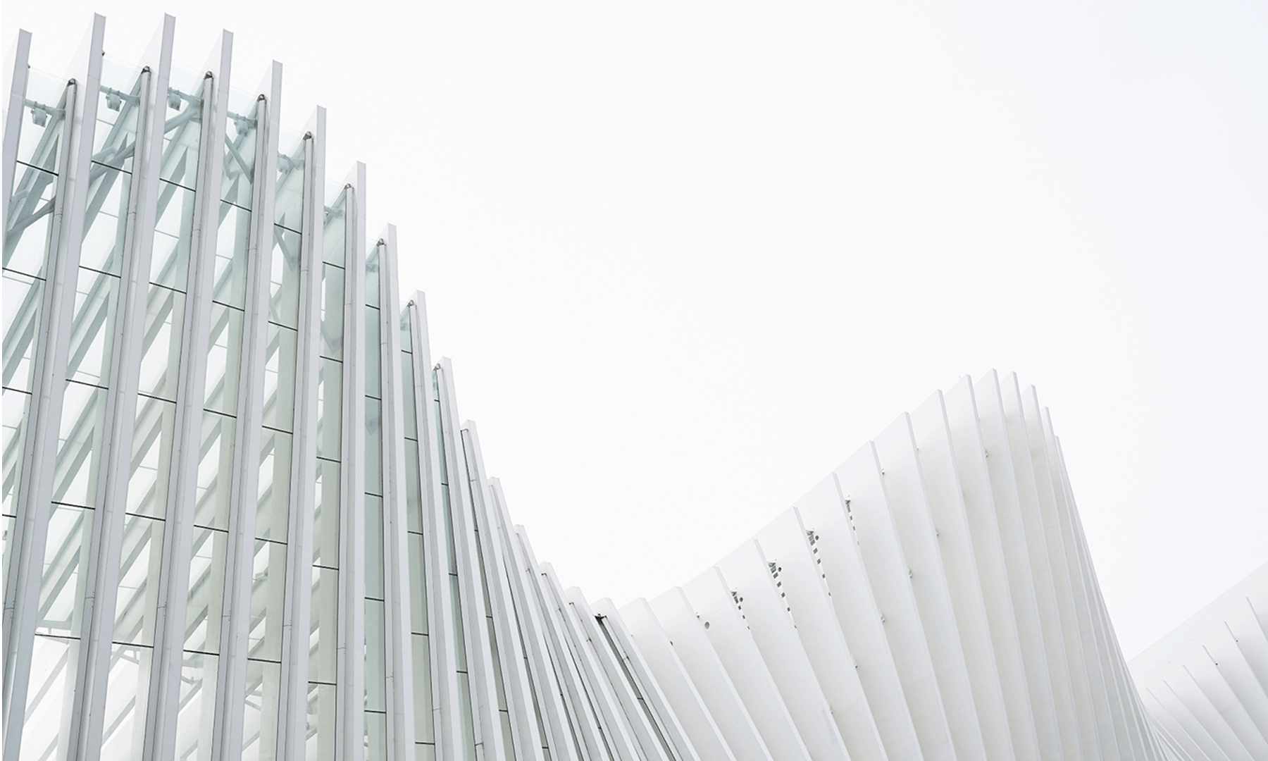 Abstract Curved White Panels Background Minimalist abstract background with layered white panels forming a soft curved spiral pattern on a light grey surface.