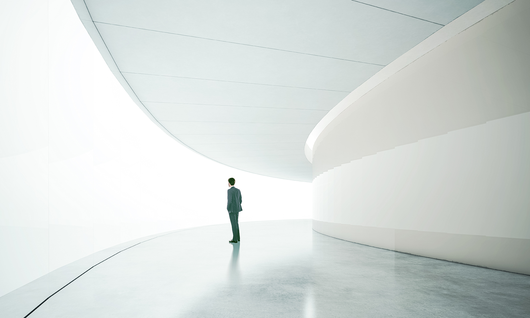 Person standing in a futuristic, minimalist corridor filled with light, symbolizing exploration, vision, and technological progress.