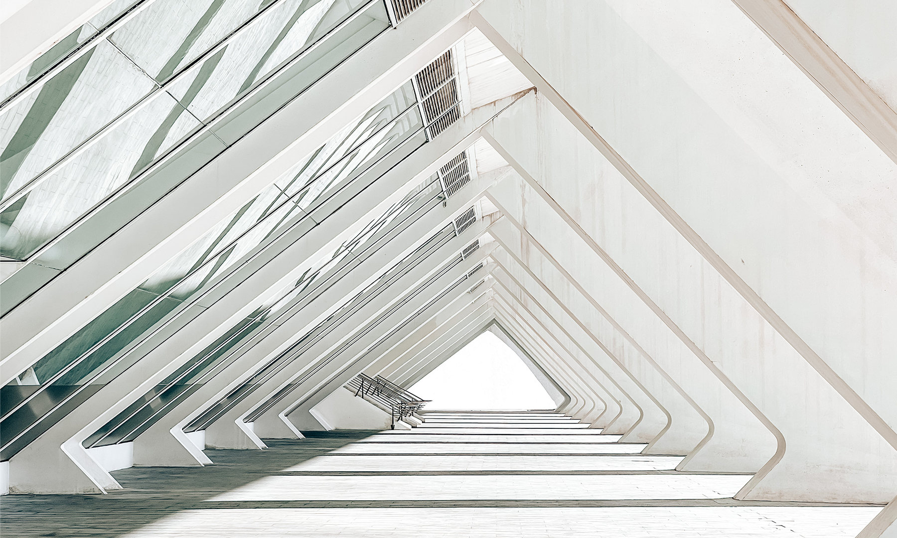 Abstract composition of layered white geometric panels forming flowing wave-like curves against a clean light background.