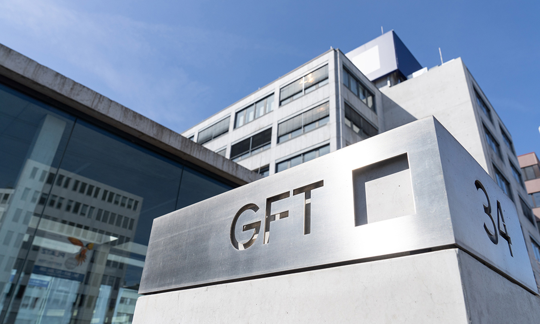 Explore o exterior da sede da GFT, exibindo o logotipo da empresa exibido com destaque em um edifício moderno. Esta imagem destaca a presença corporativa e a estética arquitetônica da GFT, refletindo seu comprometimento com a inovação e a excelência no setor de tecnologia. A sede se destaca como um símbolo do alcance global e da dedicação da GFT em fornecer soluções de ponta. gtf-key-visual-administrative-board.jpg