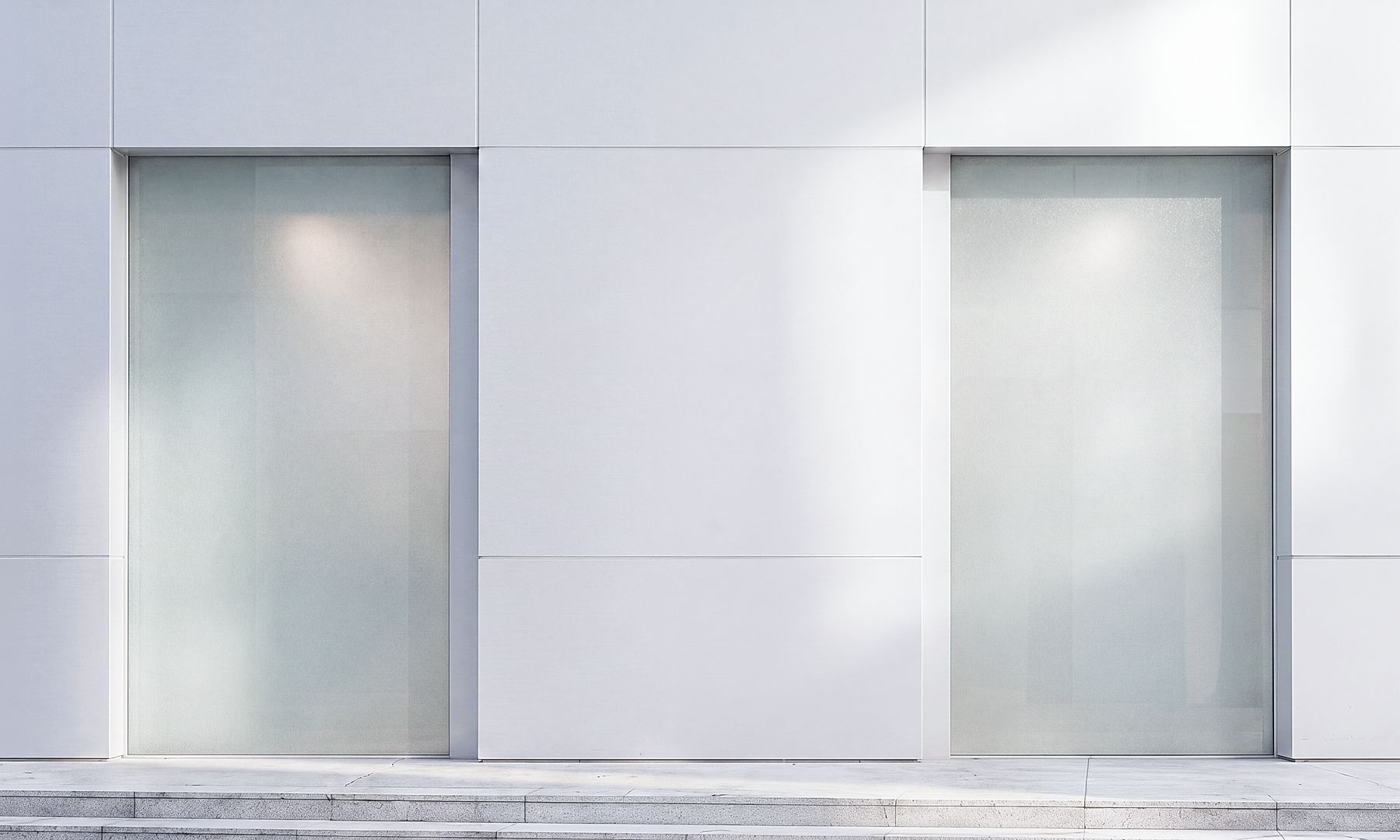 GFT Solution: Data Engineering Minimalist building facade with large frosted-glass windows and light-grey panel cladding in a modern architectural design.